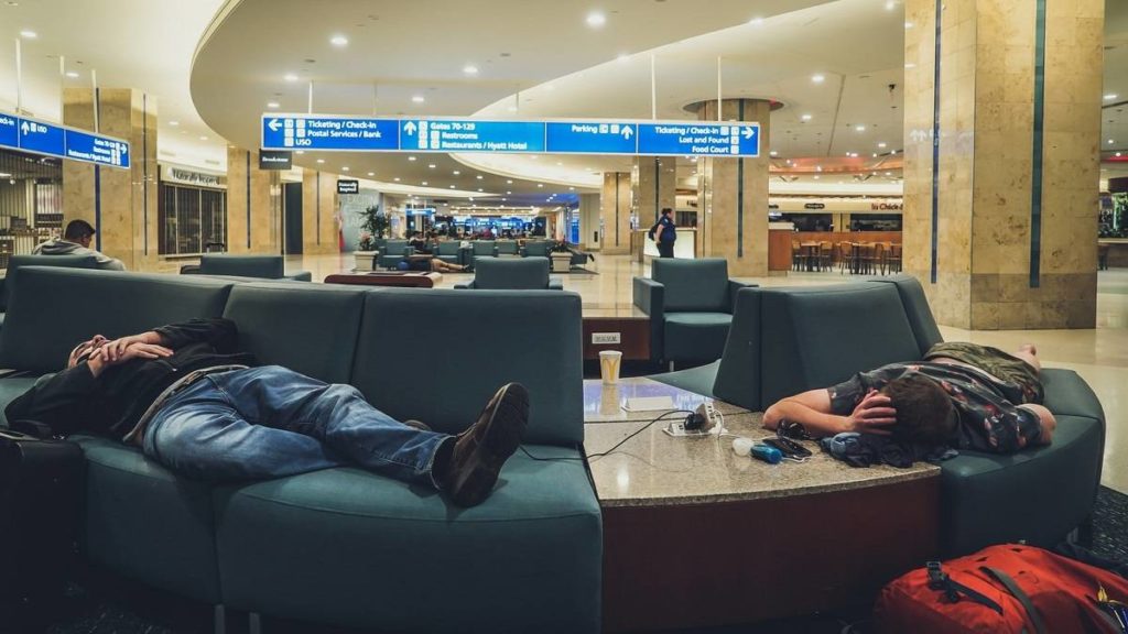 Duas pessoas a dormir no aeroporto.