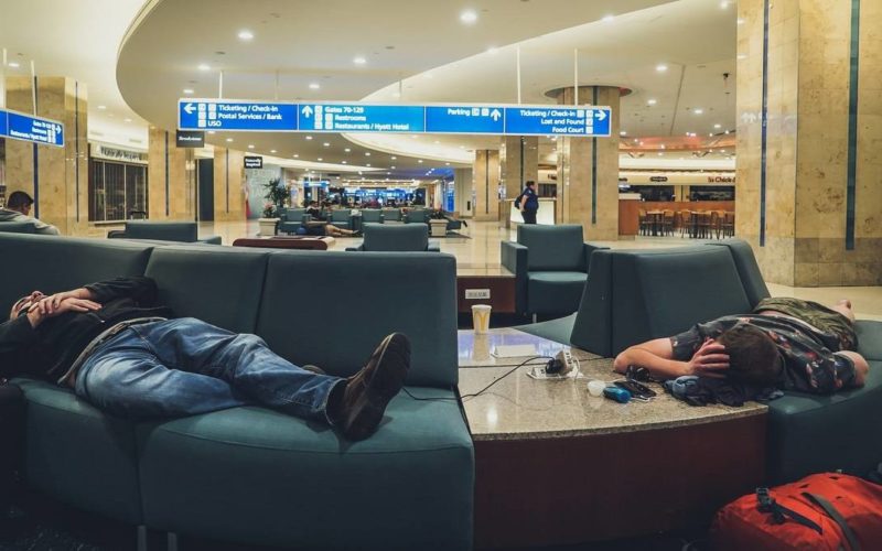 Duas pessoas a dormir no aeroporto.